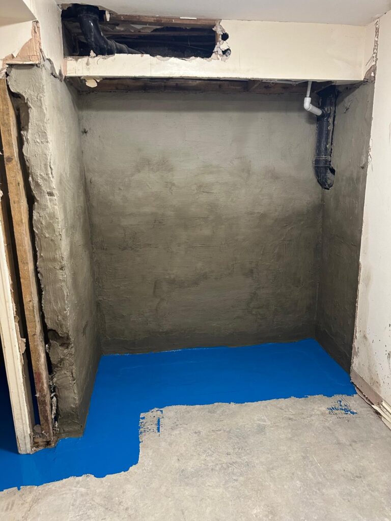 Rendered walls and blue floor coating during damp treatment
