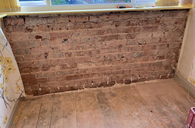 Wall stripped back to brick beneath a window